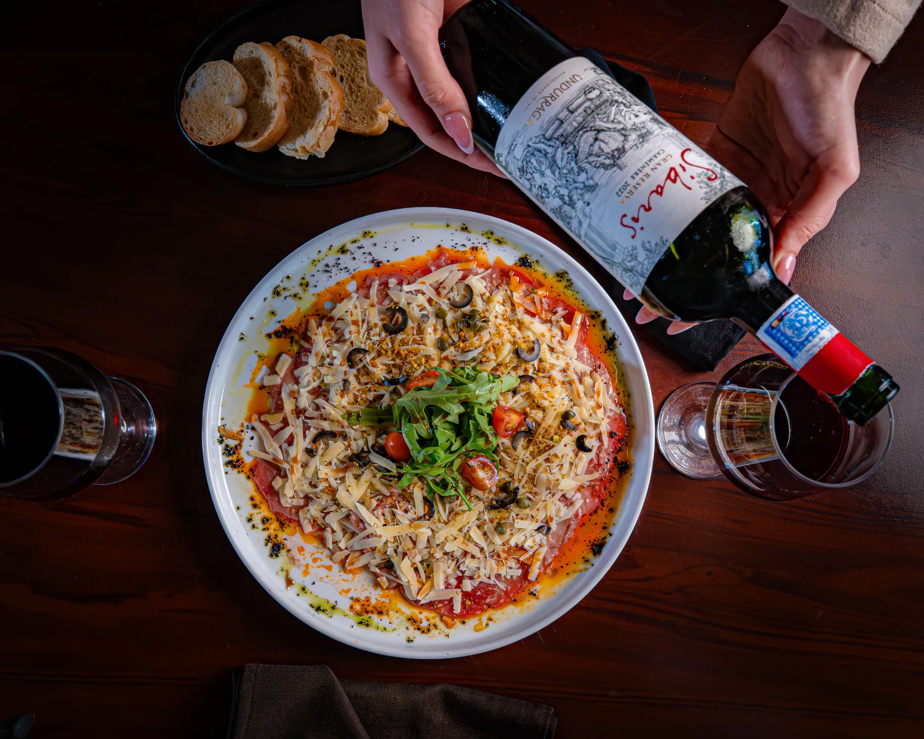 Carpaccio de res con parmesano, alcaparras y vino tinto, fotografiado por Vita Studio